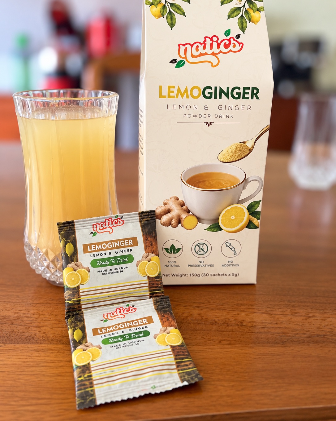Natics LemoGinger lemon and ginger powder drink box and sachets with a glass of prepared LemoGinger